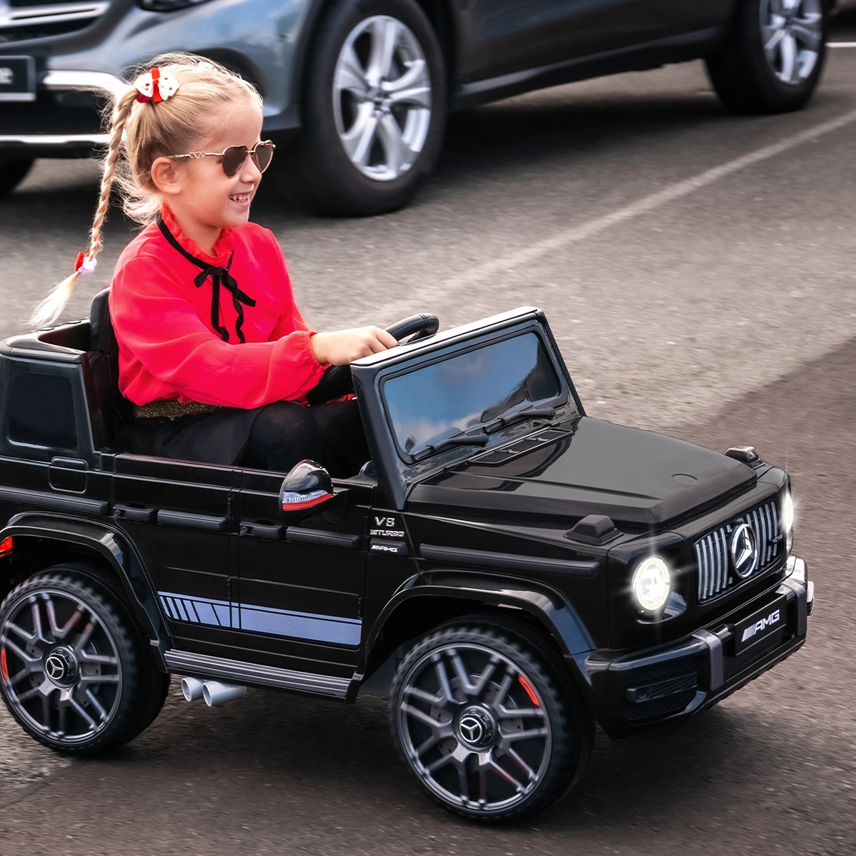 Sanft anfahren und sicher bremsen dank Bremsautomatik Mädchen steuert das Kinderauto über einen Parkplatz